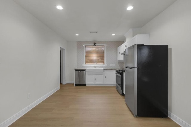2831 Jones St, Houston, TX 77026 - kitchen featuring stainless steel appliances, white cabinetry, light wood-style floors, recessed lighting, and light countertops