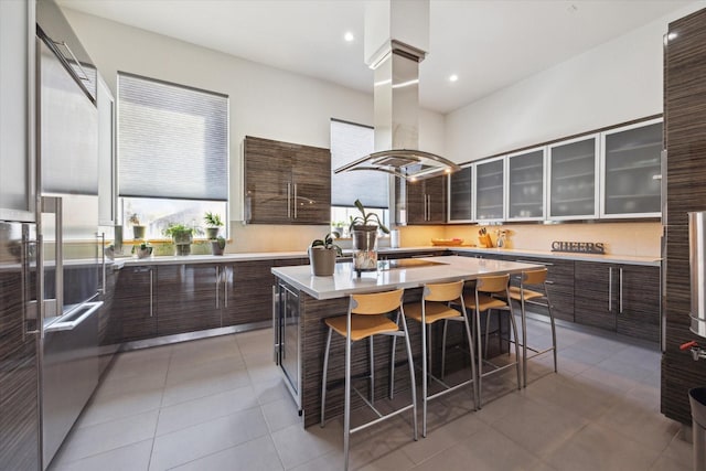 5417 Hidalgo St Unit B, Houston, TX 77056 - kitchen with island range hood, modern cabinets, light countertops, light tile patterned flooring, and recessed lighting