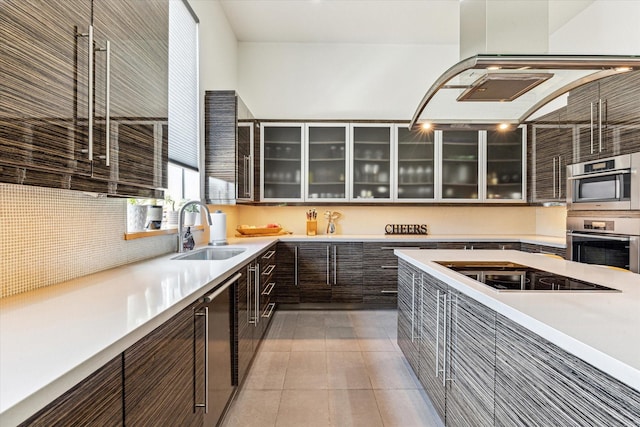 5417 Hidalgo St Unit B, Houston, TX 77056 - kitchen with a sink, black electric stovetop, dark brown cabinetry, light countertops, and glass insert cabinets