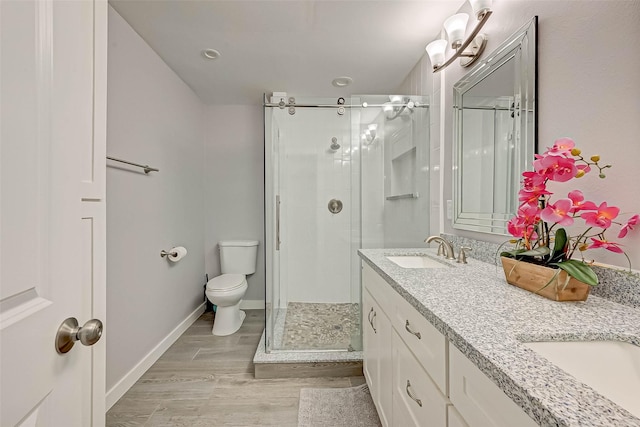 5806 Cartagena St, Houston, TX 77035 - bathroom with toilet, a shower stall, a sink, double vanity, and wood finished floors
