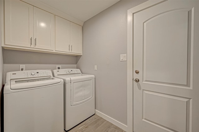 5806 Cartagena St, Houston, TX 77035 - laundry area featuring baseboards, washer and dryer, light wood-style flooring, and cabinet space