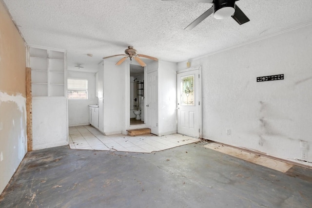 2320 Westward Ave, La Marque, TX 77568 - spare room featuring concrete flooring, a ceiling fan, and a textured ceiling