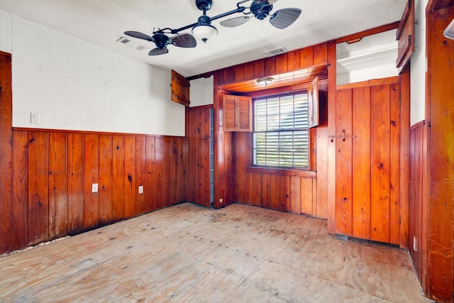 2320 Westward Ave, La Marque, TX 77568 - empty room featuring wood walls, a ceiling fan, wainscoting, and visible vents