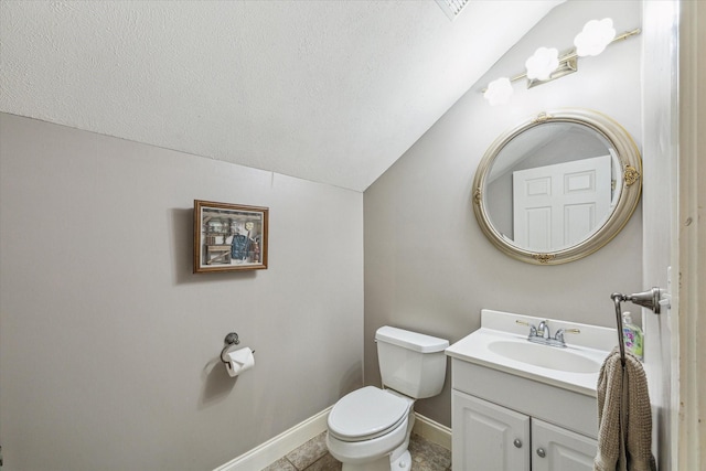 bathroom featuring toilet, a textured ceiling, vanity, baseboards, and lofted ceiling