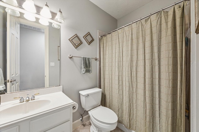 bathroom featuring toilet, vanity, a shower with curtain, baseboards, and a textured ceiling