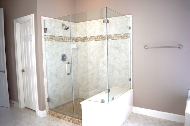 bathroom with tile patterned floors, baseboards, and a stall shower