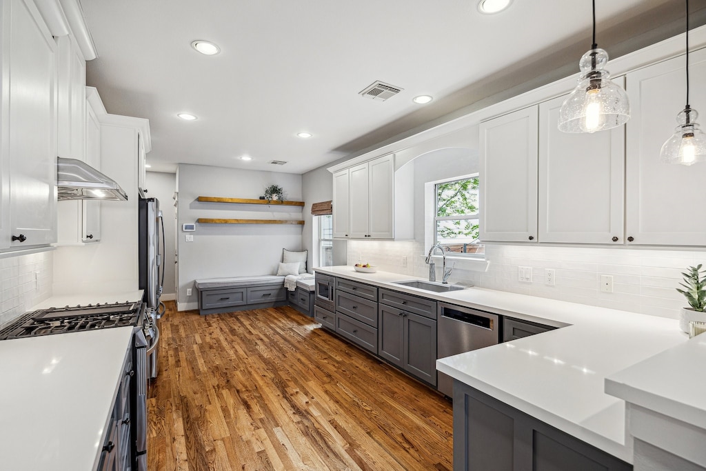 607 E 6th 1/2 St, Houston, TX 77007 - kitchen with white cabinetry, visible vents, appliances with stainless steel finishes, wood finished floors, and a sink