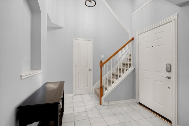 8922 Eaglecove Dr, Houston, TX 77064 - foyer entrance with light tile patterned floors, baseboards, and stairway