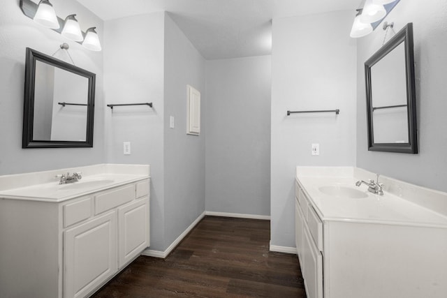 8922 Eaglecove Dr, Houston, TX 77064 - bathroom featuring a sink, two vanities, wood finished floors, and baseboards