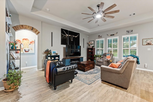 9791 Waller St, Conroe, TX 77303 - living room with visible vents, a tray ceiling, a ceiling fan, and light wood-style flooring