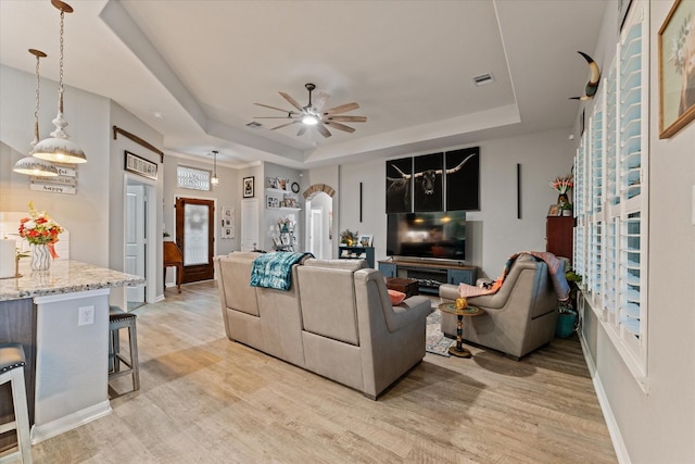 9791 Waller St, Conroe, TX 77303 - living room with a tray ceiling, a ceiling fan, visible vents, and light wood-style flooring