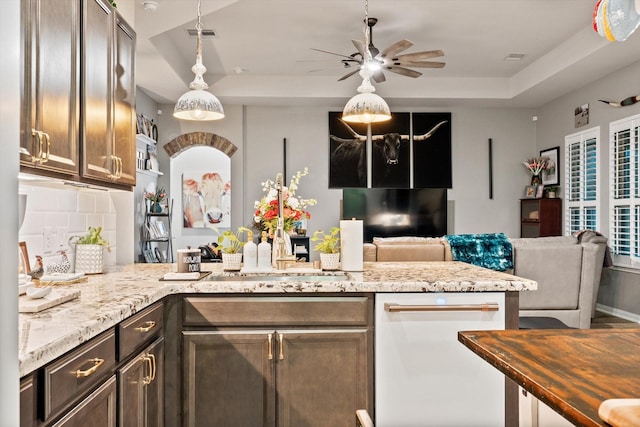 9791 Waller St, Conroe, TX 77303 - kitchen with open floor plan, a peninsula, a tray ceiling, decorative backsplash, and ceiling fan