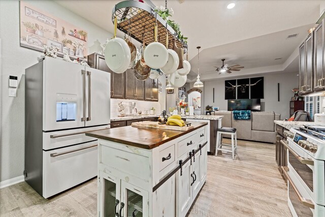 9791 Waller St, Conroe, TX 77303 - kitchen with light wood finished floors, white appliances, wood counters, and a ceiling fan