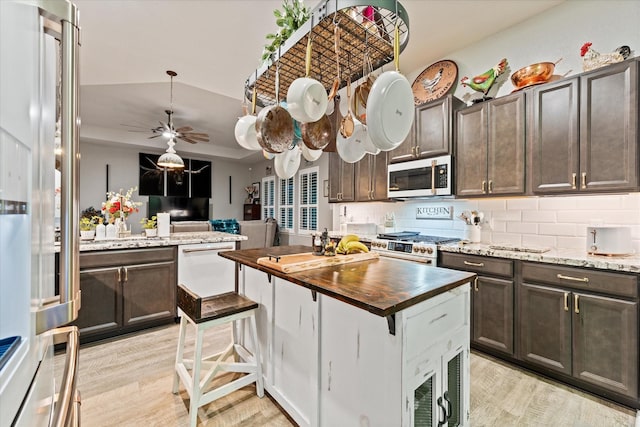9791 Waller St, Conroe, TX 77303 - kitchen featuring tasteful backsplash, dark brown cabinets, high quality appliances, and butcher block counters