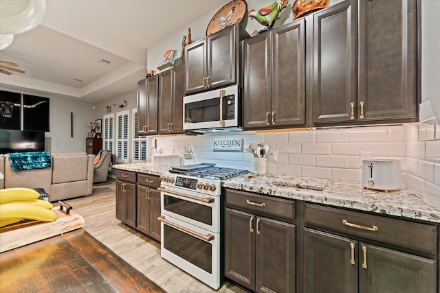 9791 Waller St, Conroe, TX 77303 - kitchen featuring light wood-type flooring, open floor plan, light stone countertops, decorative backsplash, and double oven range
