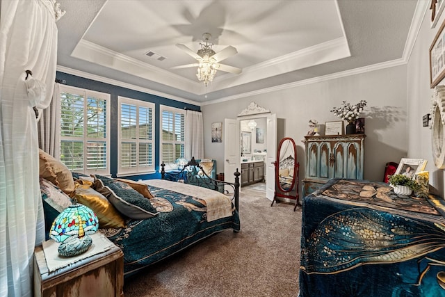 9791 Waller St, Conroe, TX 77303 - carpeted bedroom featuring ornamental molding, ensuite bathroom, visible vents, a tray ceiling, and ceiling fan