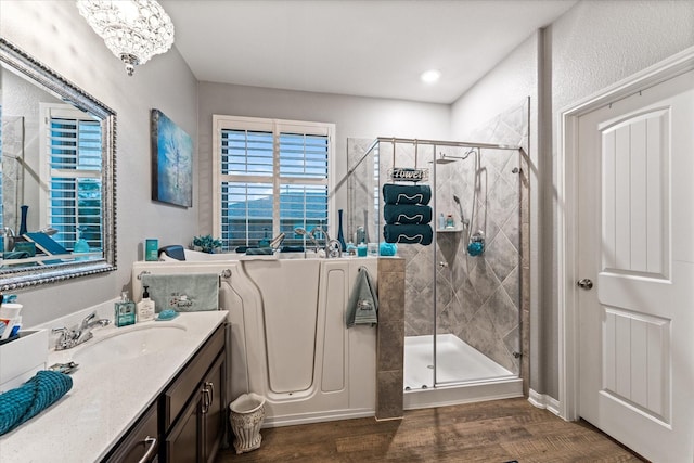 9791 Waller St, Conroe, TX 77303 - full bath with a shower stall, wood finished floors, vanity, and an inviting chandelier
