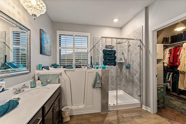 9791 Waller St, Conroe, TX 77303 - full bath with an inviting chandelier, vanity, a spacious closet, wood finished floors, and a stall shower