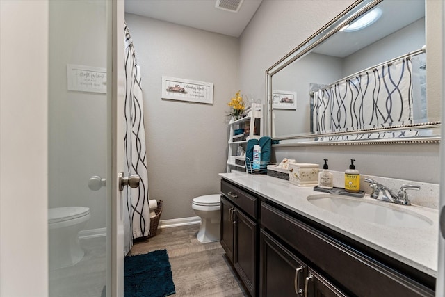 9791 Waller St, Conroe, TX 77303 - bathroom with vanity, baseboards, toilet, visible vents, and wood finished floors