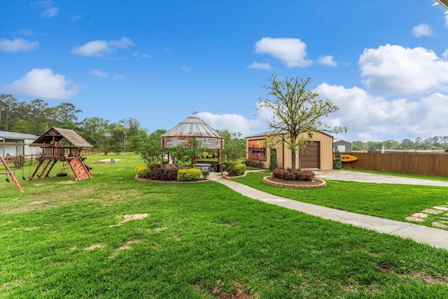 9791 Waller St, Conroe, TX 77303 - view of yard featuring a detached garage, fence, a playground, and driveway