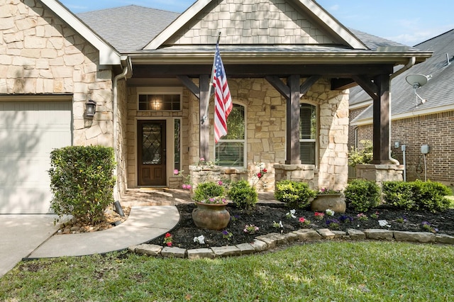 doorway to property with stone siding, a garage, and roof with shingles