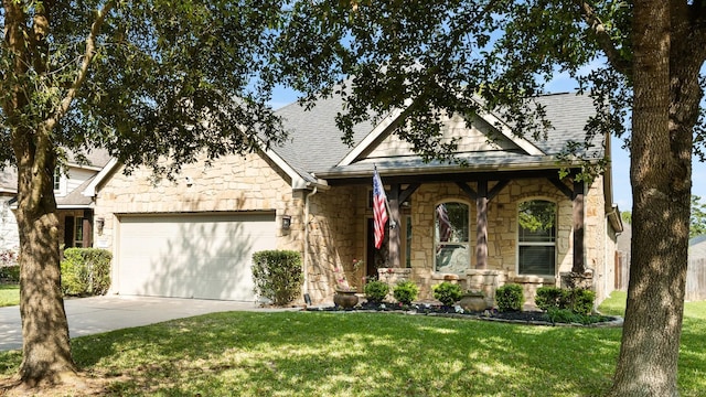 view of front facade featuring stone siding, a garage, concrete driveway, a front lawn, and a shingled roof