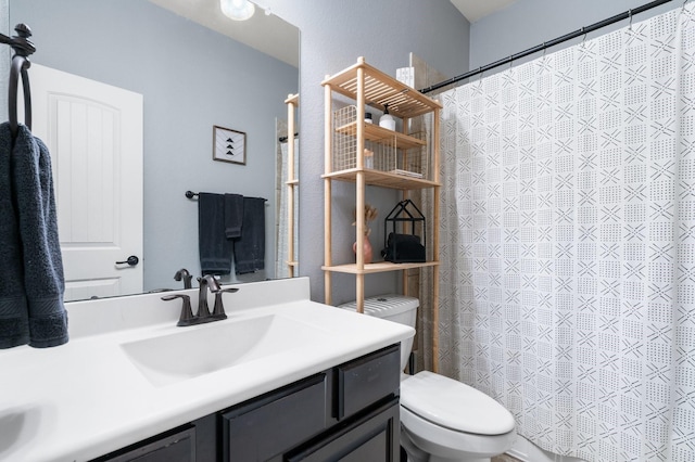 bathroom featuring toilet, vanity, and curtained shower