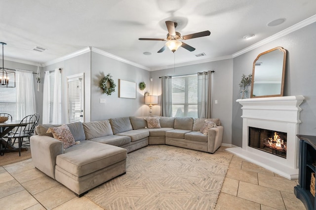 living room with a warm lit fireplace, visible vents, ceiling fan, ornamental molding, and light tile patterned floors