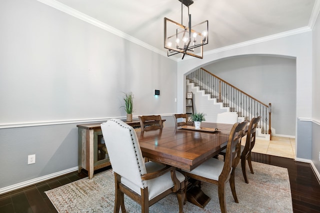 dining room with a notable chandelier, crown molding, stairway, and wood finished floors