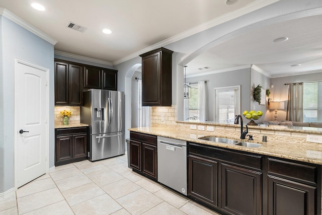 kitchen featuring dark brown cabinetry, a sink, appliances with stainless steel finishes, visible vents, and arched walkways