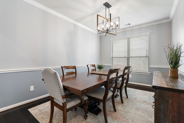 dining room featuring ornamental molding, visible vents, an inviting chandelier, and wood finished floors