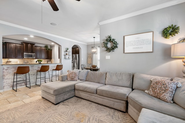 living room with a ceiling fan, arched walkways, crown molding, and recessed lighting