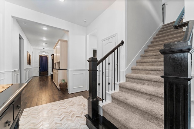 11202 Puckett River Dr, Cypress, TX 77433 - stairway featuring wood finished floors, a wainscoted wall, and a decorative wall