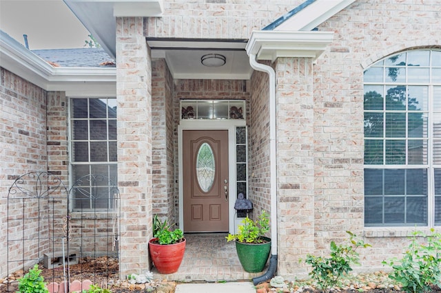doorway to property featuring brick siding