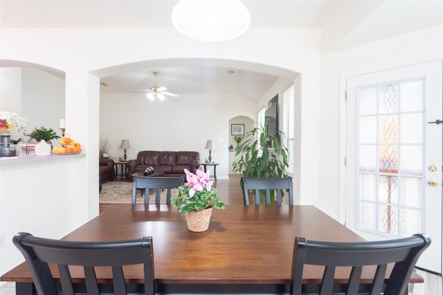 dining room with arched walkways, a ceiling fan, and healthy amount of natural light