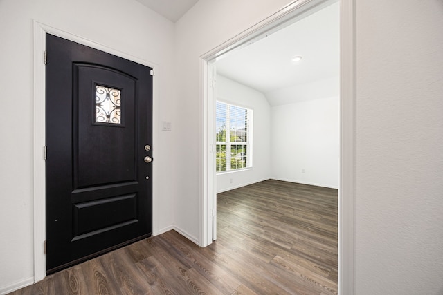 foyer with dark wood finished floors, vaulted ceiling, and baseboards