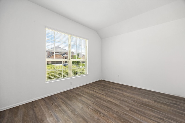 unfurnished room featuring lofted ceiling, dark wood-type flooring, and baseboards