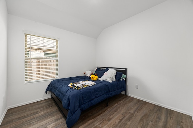 bedroom with baseboards, vaulted ceiling, and wood finished floors