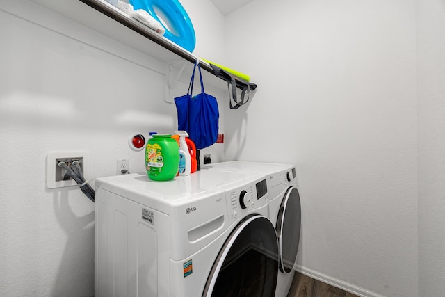 washroom featuring baseboards, dark wood-style flooring, washer and clothes dryer, and laundry area