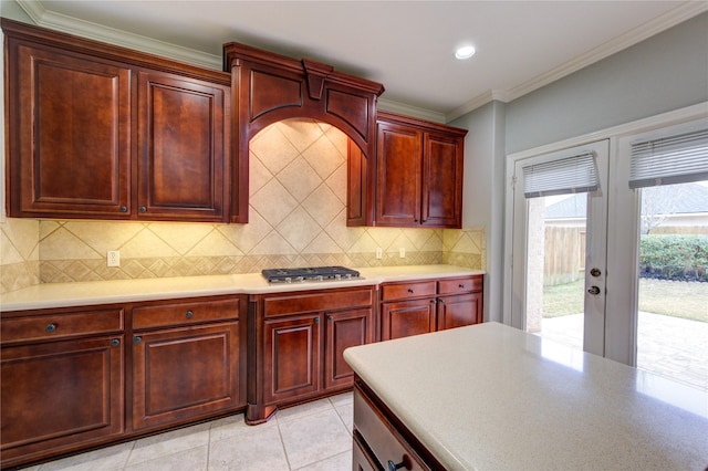 13214 Dusty Grove Ln, Sugar Land, TX 77498 - kitchen featuring french doors, reddish brown cabinets, light countertops, tasteful backsplash, and crown molding