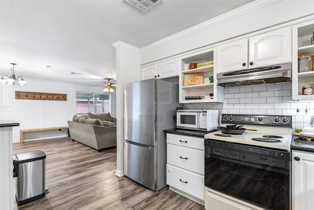 507 E Linney St, Dayton, TX 77535 - kitchen featuring open shelves, freestanding refrigerator, under cabinet range hood, range with electric cooktop, and white microwave