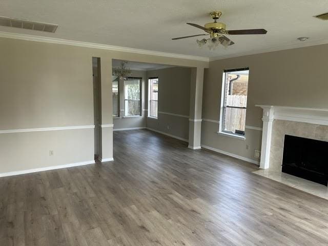 unfurnished living room with wood finished floors, visible vents, and plenty of natural light