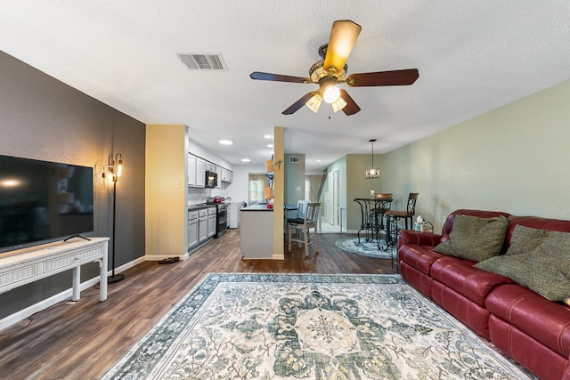 6506 Kentwick Dr, Houston, TX 77084 - living area featuring a textured ceiling, dark wood-type flooring, ceiling fan, and visible vents