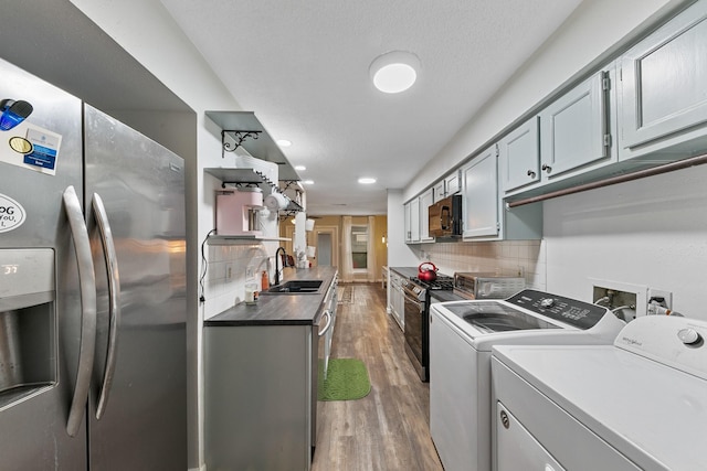 6506 Kentwick Dr, Houston, TX 77084 - kitchen with decorative backsplash, independent washer and dryer, light wood finished floors, stainless steel appliances, and a sink