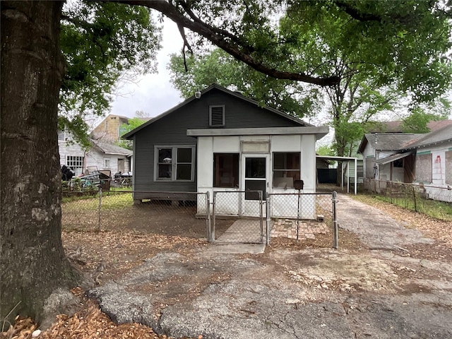 view of front facade featuring an attached carport, a gate, and fence