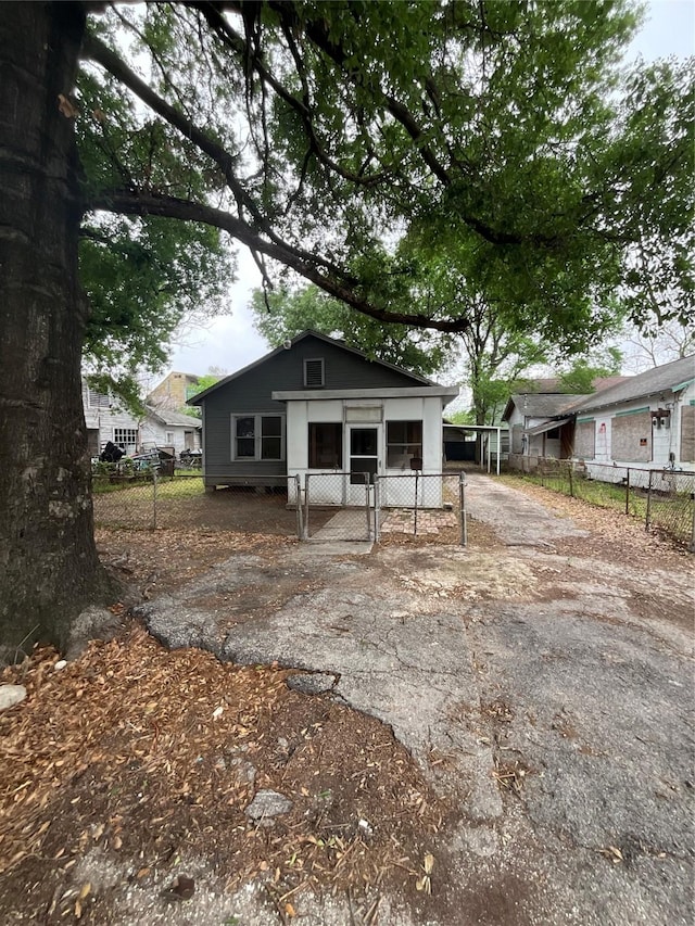 back of house featuring driveway and fence