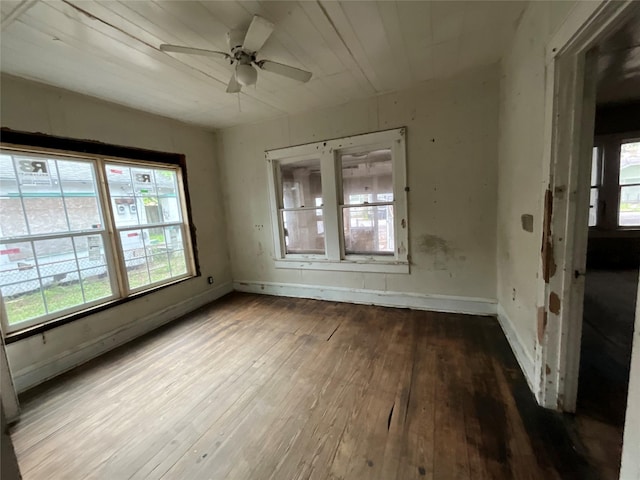 spare room with hardwood / wood-style floors, baseboards, and a ceiling fan