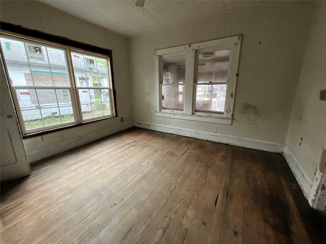 empty room featuring hardwood / wood-style flooring and baseboards