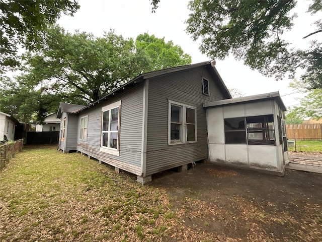exterior space featuring a yard, a sunroom, and fence