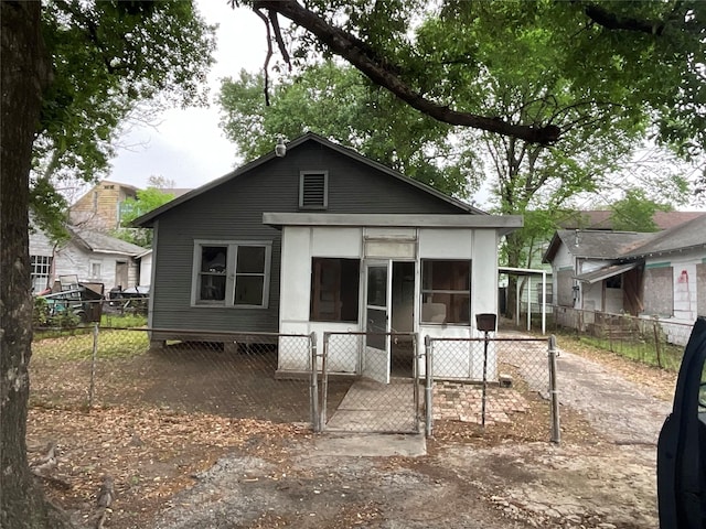 back of property featuring fence private yard, a sunroom, and a gate